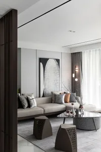 A modern living room with neutral-toned furniture and a large abstract painting.