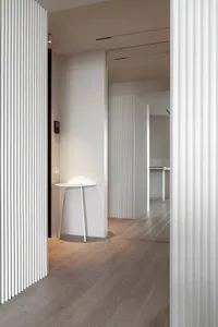 A modern kitchen with white cabinets and hardwood floors.
