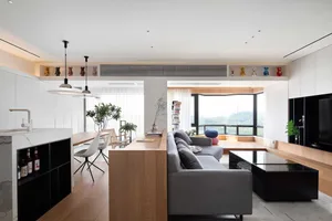 Modern open-concept living room and kitchen with wood, composite, and metal materials.