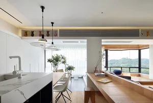 Modern kitchen featuring white marble countertops and wooden furniture.