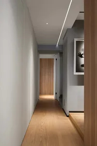 A minimalist hallway with wooden flooring and a light fixture.
