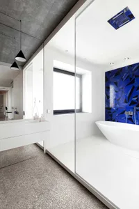 A modern bathroom featuring glass tiles on the walls and floor.