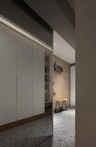 現代簡約更衣室，搭配水磨石地板與內建燈光的白色櫃體。