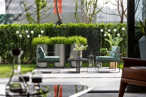 Modern outdoor seating area with metal chairs and greenery