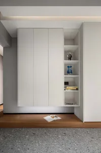 Modern minimalist storage shelves with white doors, featuring open shelving and decorative items on the right side.