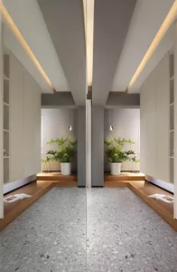 Modern living room featuring gray terrazzo tiles, white built-in shelves, and potted plants with green leafy plants.
