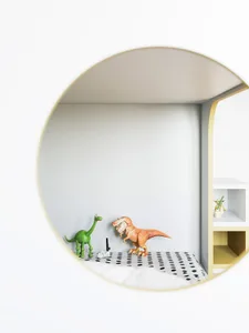 Childrens' room with a modern design, featuring a round window, a green dinosaur and an orange dinosaur toy on a shelf, and a