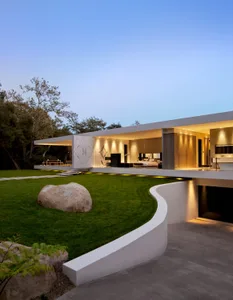 A sleek, contemporary residential interior featuring a wall of glass