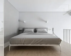 A minimalist bedroom with gray walls and a wooden bed frame.
