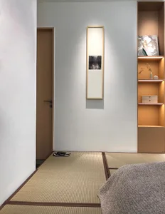 A minimalist bedroom with a woven mat floor