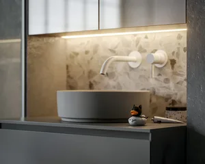 A modern minimalist bathroom featuring a round sink with a wall-mounted faucet, a terrazzo backsplash, and a small duck figur