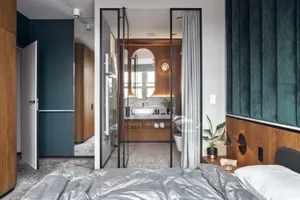 Spacious modern bedroom with wooden walls and grey bedding