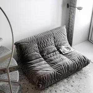 Gray sofa with tufted design and plush upholstery in a modern living room setting.