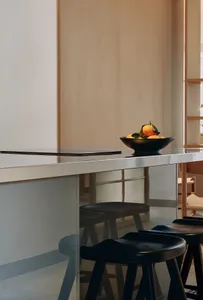 A sleek, modern kitchen counter made of metal with a bowl of oranges on top.
