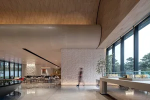 Modern minimalist lobby interior with concrete walls and large windows.