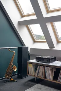 Modern music room featuring glass and wood materials with industrial lighting.