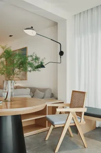 Modern residential interior featuring wood furniture, fabric seating, and glass windows.