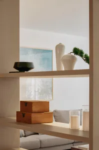 A modern shelf featuring wooden boxes and ceramic vases.