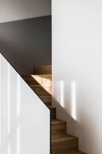 Modern staircase with wooden steps and a white wall