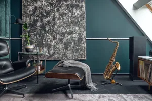 A modern living room featuring a faux leather ottoman and a saxophone on the floor.