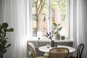 A modern dining room featuring wooden chairs and metal table.