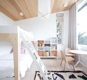 A minimalistic bedroom featuring a wooden bunk bed with a white ladder, a wooden chair, and a wooden bookshelf.