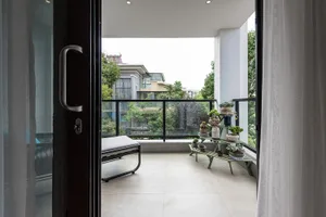 Modern balcony with floor tiles, glass railings, and wooden furniture
