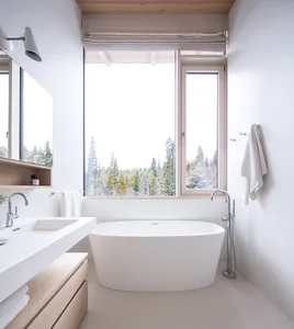 Modern bathroom featuring a white concrete tub, a large window overlooking a snowy forest, and minimalist fixtures.
