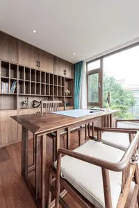 A modern home office featuring wooden furniture and a large window.