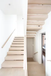 Modern interior with wooden stairs and white walls.