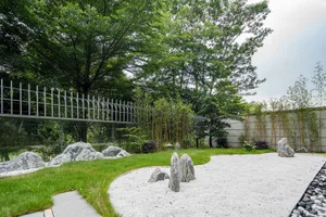 現代日式庭園中，平滑石頭排列於礫石與小石子之間，環繞綠草與竹子植栽