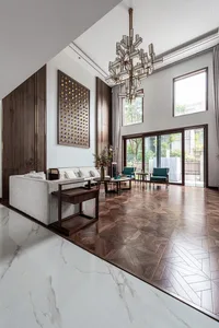 A modern living room with marble flooring and wooden furniture.