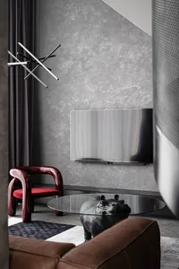 Modern living room featuring metal chandelier, glass coffee table, leather sofa, and fabric accents