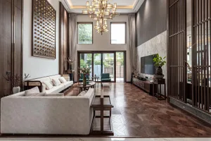 A modern living room with mixed materials, featuring white sofas, wooden tables, a wooden floor, and a large screen TV.