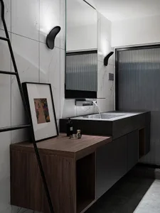 A modern marble bathroom with a minimalist design, featuring a concrete countertop and black accents.