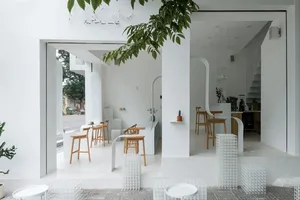 A minimalist cafe interior with white furniture and modern design elements.