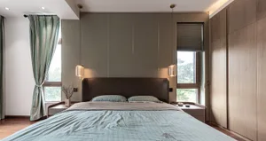A modern bedroom featuring fabric bedding, wooden furniture, and metal accents.