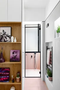 Modern bathroom with pink porcelain flooring, white concrete walls, and wooden shelving.