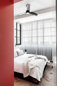 A modern minimalist bedroom featuring a bed with white bedding, wood floors, and a metal frame.