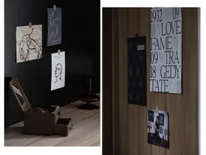 Black decorative panels with various designs pinned onto a wooden surface.