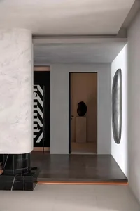 Modern entrance hall featuring concrete walls and a sculptural light fixture