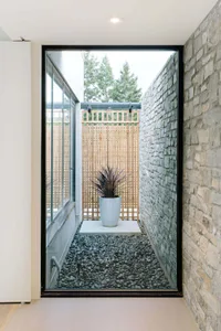 A sleek, modern entrance featuring a concrete planter with succulent plant.