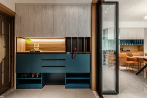 A modern interior design featuring a blue storage unit with wooden panels and metallic accents.