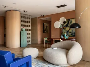 Modern interior featuring a fabric sofa, circular lighting fixtures, and wood flooring.