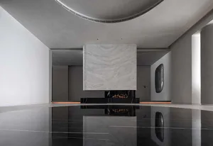 An elegantly designed living room featuring a modern fireplace enclosed in a black marble slab with a glass insert.