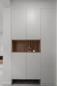 A modern metal cabinet with a wooden shelf featuring a sculpture and small candles.