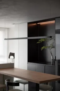 A modern minimalist kitchen featuring wooden countertops, metal accents, and glass cabinets.