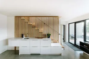 Modern minimalist kitchen featuring a white countertop and wooden accents.