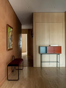 A modern minimalist living room with wooden furniture and a large wooden cabinet