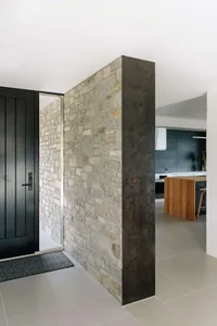 A minimalist interior featuring a stone wall